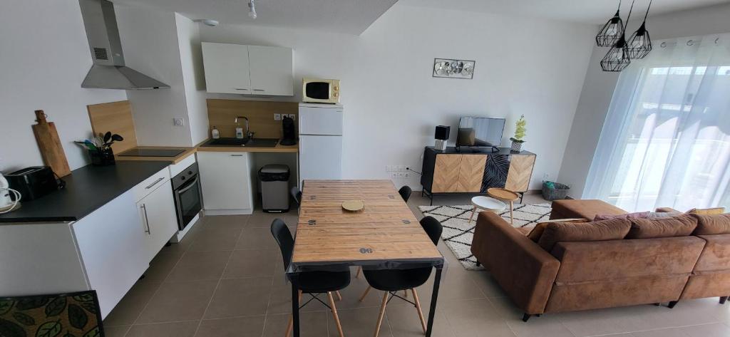 kuchnia i salon ze stołem i kanapą w obiekcie Appartement avec balcon/terrasse w mieście Monteux