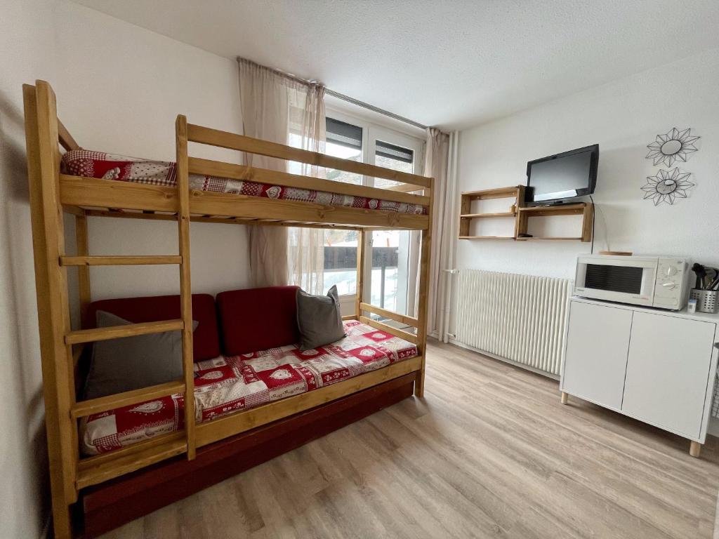 a bedroom with two bunk beds and a microwave at Studio au coeur de la station des Menuires in Les Menuires