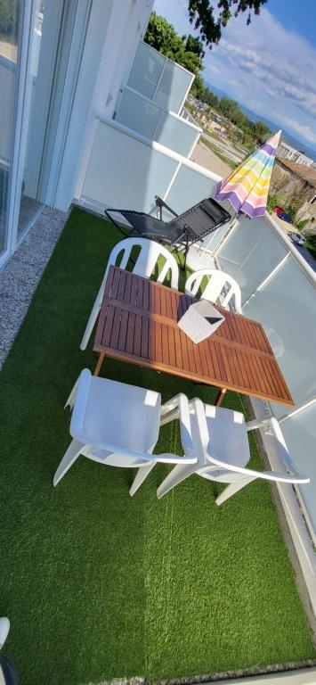 patio con 2 sedie e tavolo sull'erba di Appartement avec balcon/terrasse a Monteux