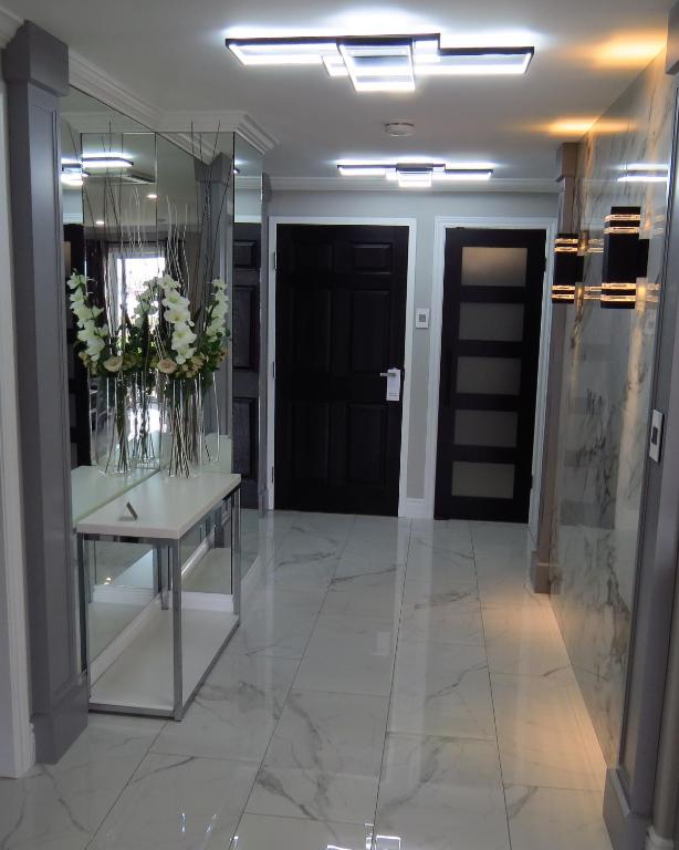 a hallway with a table with flowers in a mirror at Dockside Suites in Digby