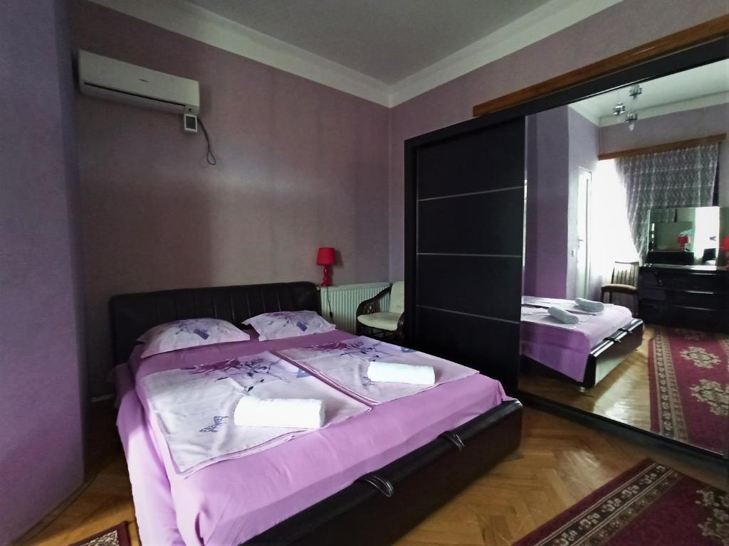 a bedroom with two beds and a large mirror at GuestHouse LILIA &Wine Celler in Tʼelavi