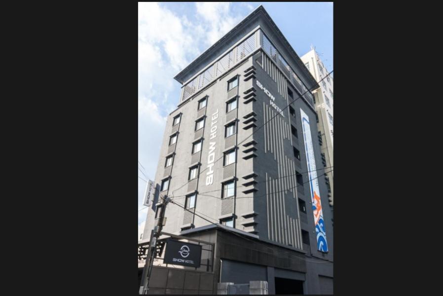 a tall building with a sign on the side of it at Show Hotel Haeundae in Busan