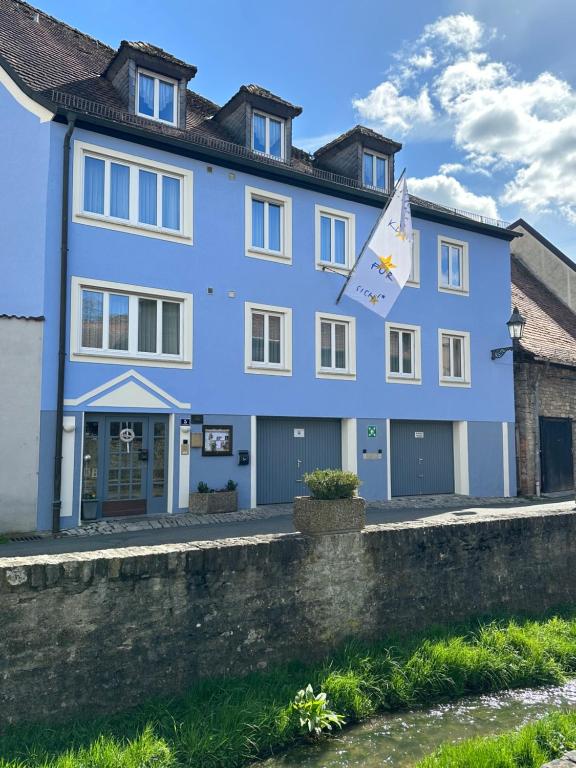 ein blaues Gebäude mit einem Drachen davor in der Unterkunft AKZENT Hotel Am Bach in Dettelbach