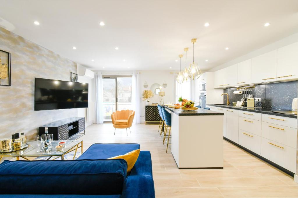 Il comprend une cuisine et un salon doté d'un canapé bleu. dans l'établissement Elena YourHostHelper, à Cannes