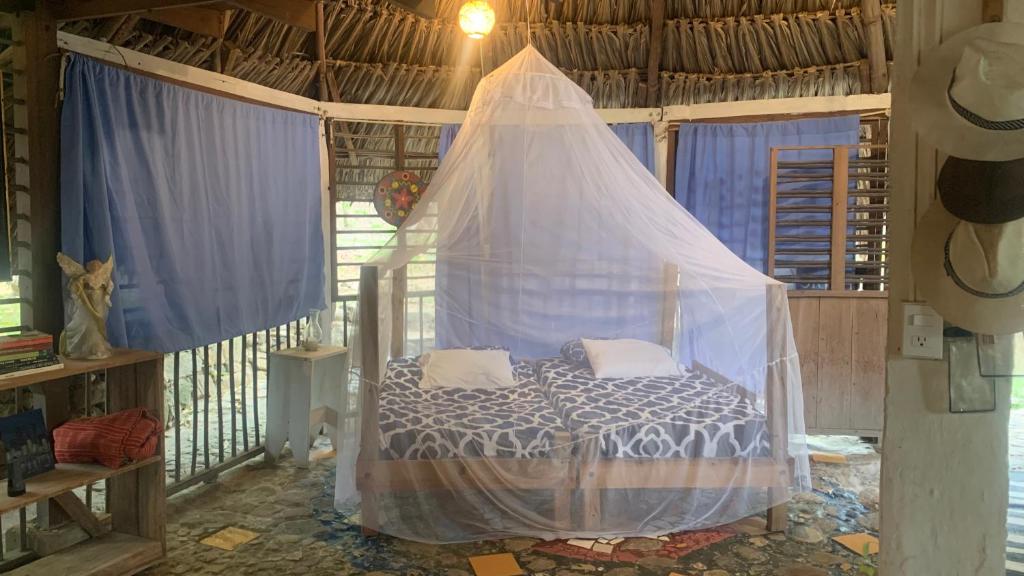 a bed in a room with a mosquito net at Private Beach with a Jungle Loft in Palomino