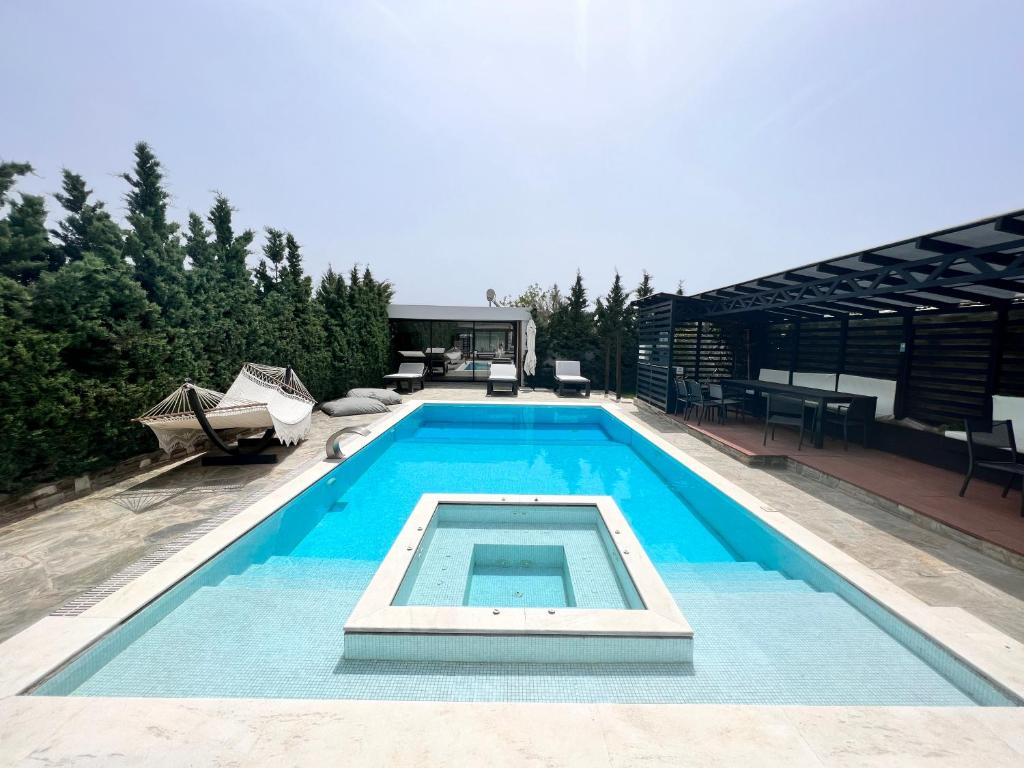 a swimming pool on top of a house at Olivujoj Villajoj - Deluxe Villa with Detached Pool House in Anavyssos