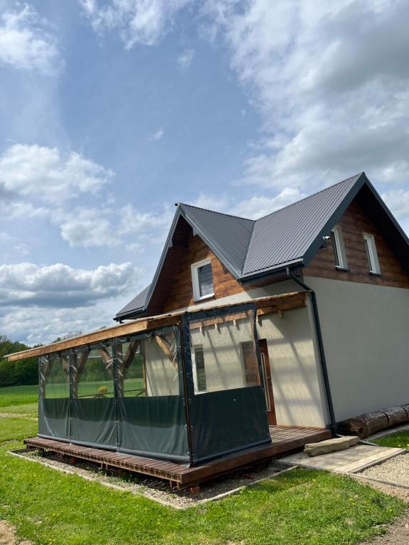 a house with a greenhouse on the front of it at Noclegi Dąbek in Rymanów