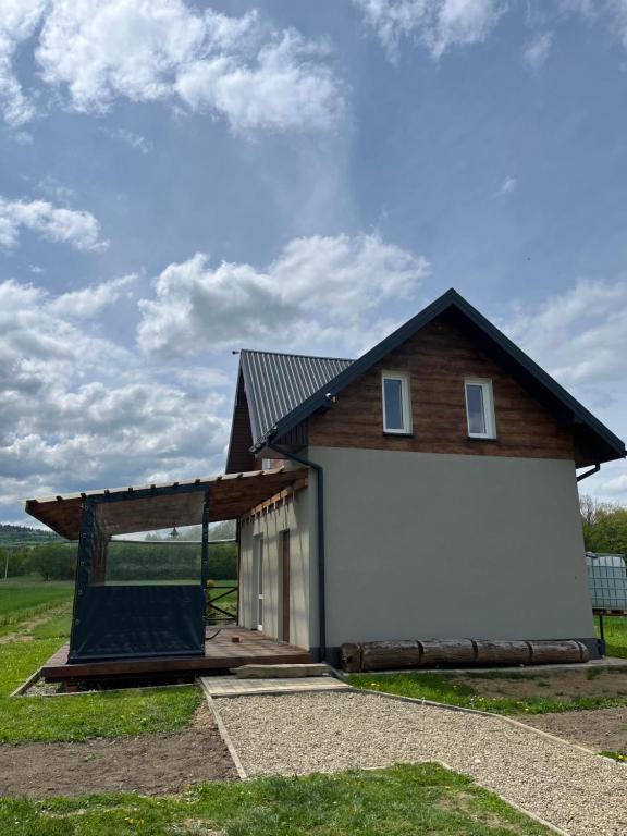 uma pequena casa com um alpendre e um telhado em Noclegi Dąbek em Rymanów