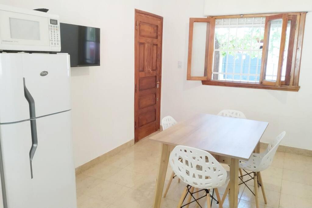 a kitchen with a wooden table and a refrigerator at Alquiler por dia Departamento 3 personas Gral Roca Casita Artigas in General Roca