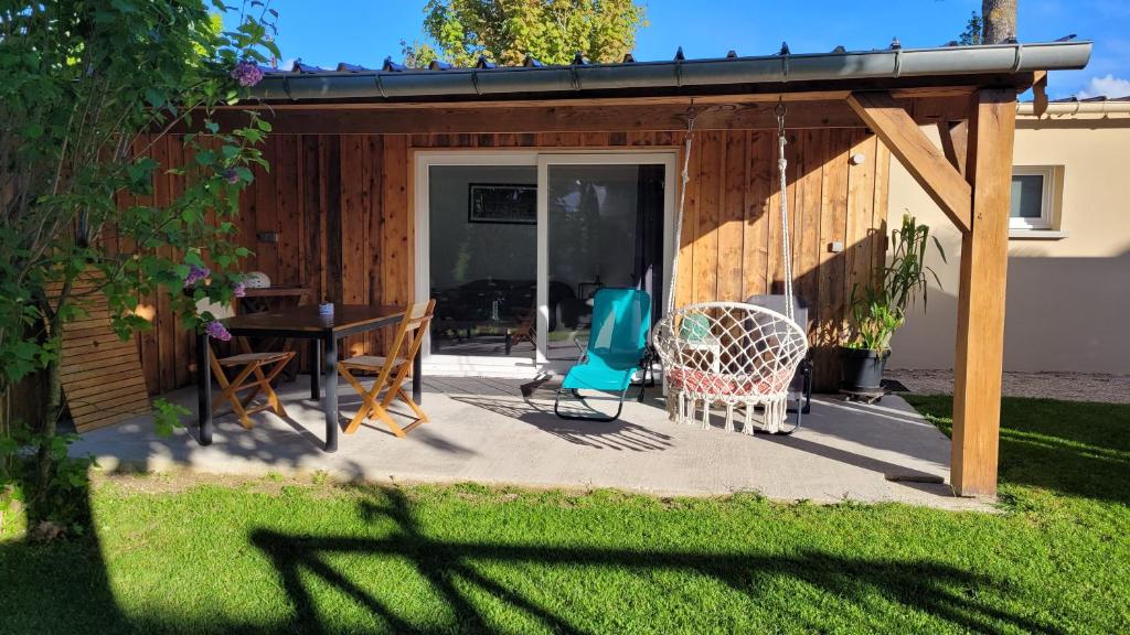 un patio con tavolo e sedie accanto a un edificio di Cabanon Mairyon a Mairy-sur-Marne