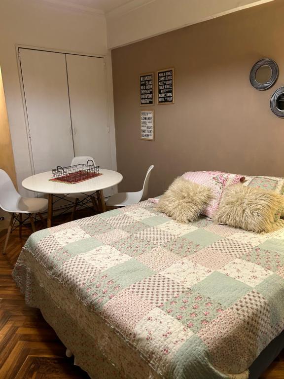 Un dormitorio con una cama y una mesa con una mesa. en Departamento Impecable en Balvanera en Buenos Aires