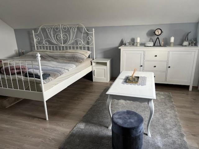 a bedroom with a white bed and a table at Ivekova klet, kuća za odmor in Ključić Brdo