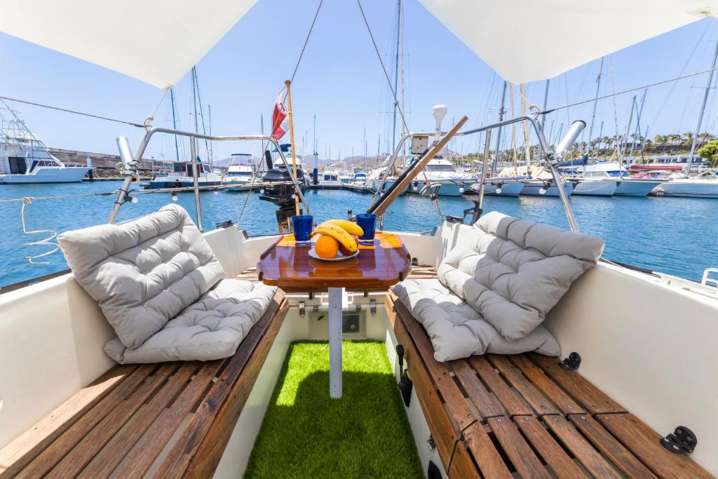 Seaside Chill-out Stay on a Sail Yacht في بويرتو كاليرو: كرسيين وطاولة على ظهر قارب