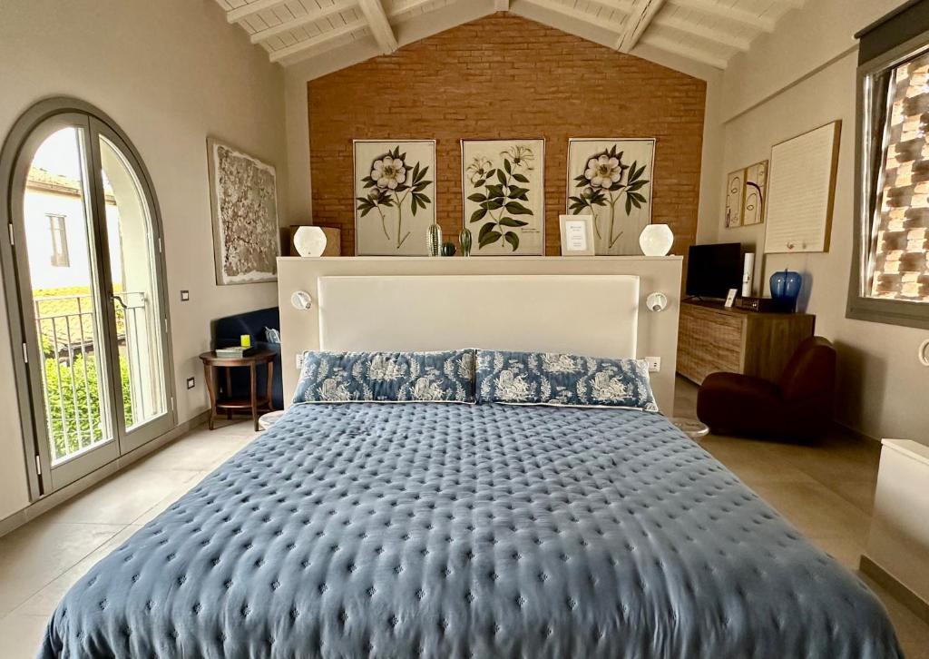 a bedroom with a large bed with a blue comforter at Podere Milla in Montale