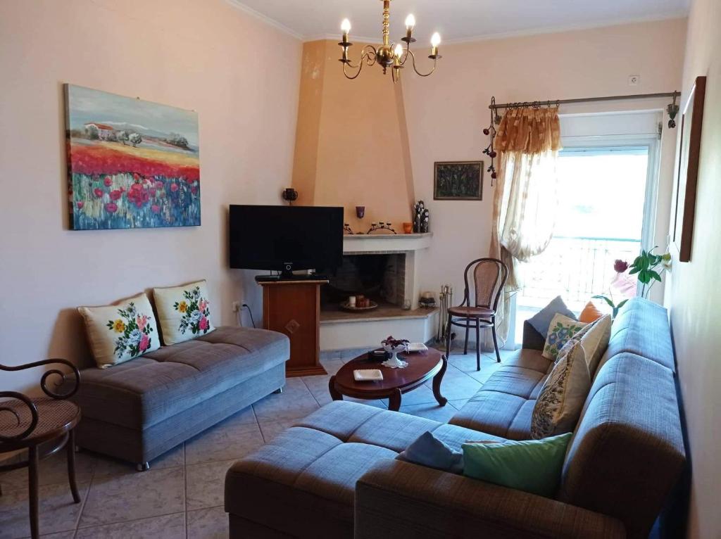 sala de estar con 2 sofás y TV en George Geust House en Oropós