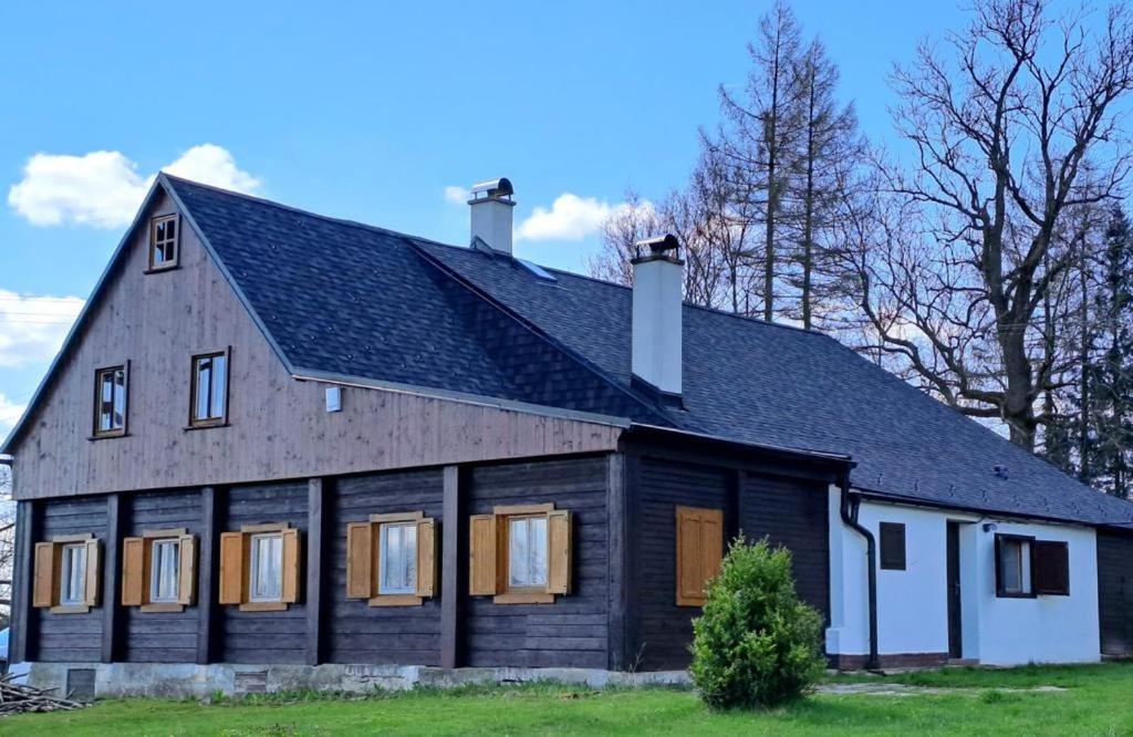 a large wooden house with a gambrel roof at Chalupa Lichtenberg/ Světlík in Horní Podluží