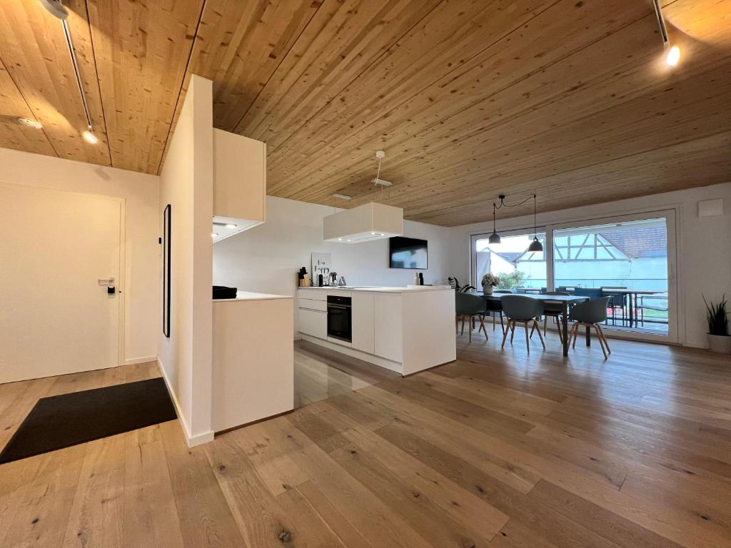 een keuken en een woonkamer met een houten plafond bij STAY in Uhldingen-Mühlhofen