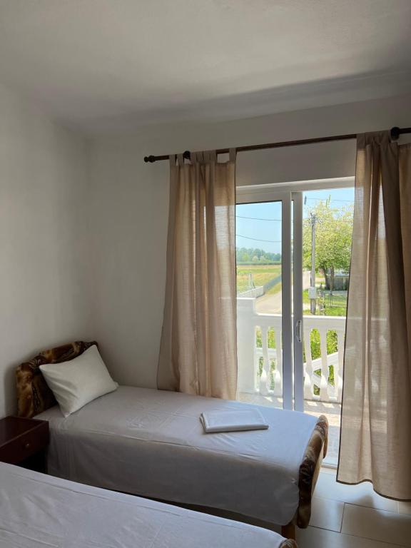 Schlafzimmer mit einem Bett und einem Fenster mit einem Balkon in der Unterkunft Kastrati Apartments in Ulcinj