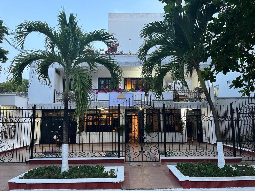 einen schmiedeeisernen Zaun mit zwei Palmen vor einem Gebäude in der Unterkunft Hostal Boutique Casa Pere in Cartagena de Indias