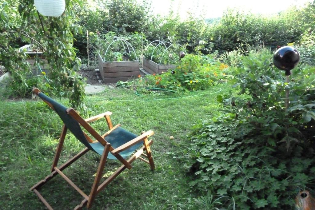 a chair sitting in the grass in a garden at B&B Rosenrot 