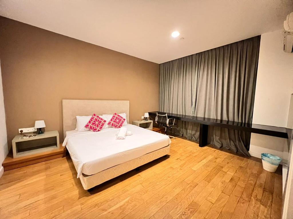 um quarto com uma cama com almofadas vermelhas em Platinum Suites KLCC em Kuala Lumpur