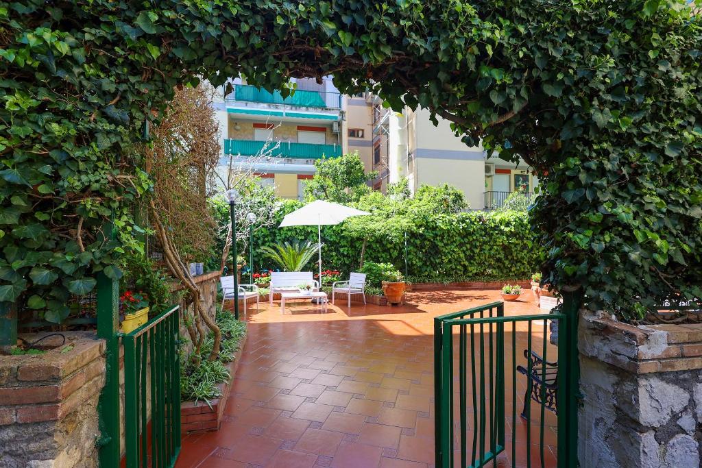 un jardin avec une porte verte et une terrasse dans l'établissement Garden House Giulia, à Sorrente