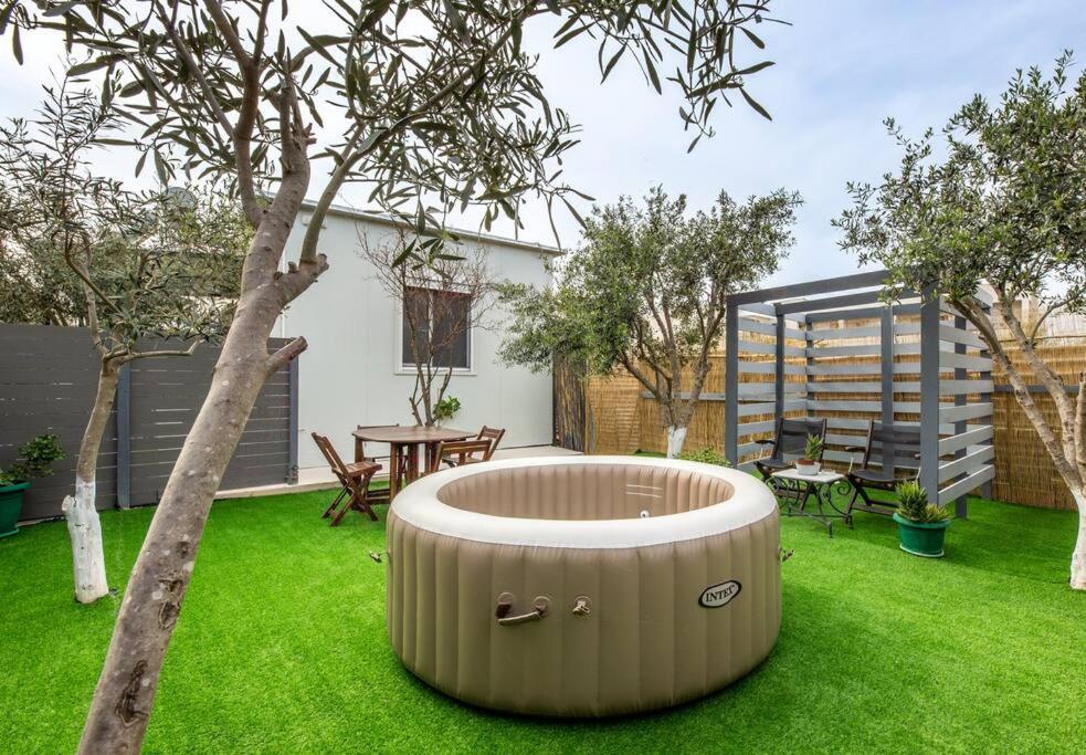 a garden with a tree and a tub in the grass at The Home Away from Home with Hot Tub in Lampi