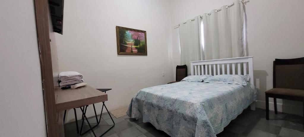 1 dormitorio con 1 cama y 1 mesa con silla en SUÍTE Nº 4 - próximo a feira da sulanca caruaru-PE, en Caruaru