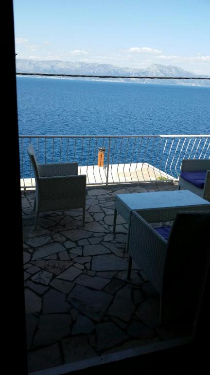 a balcony with tables and chairs and a view of the water at Villa Teodora in Donja Vrućica