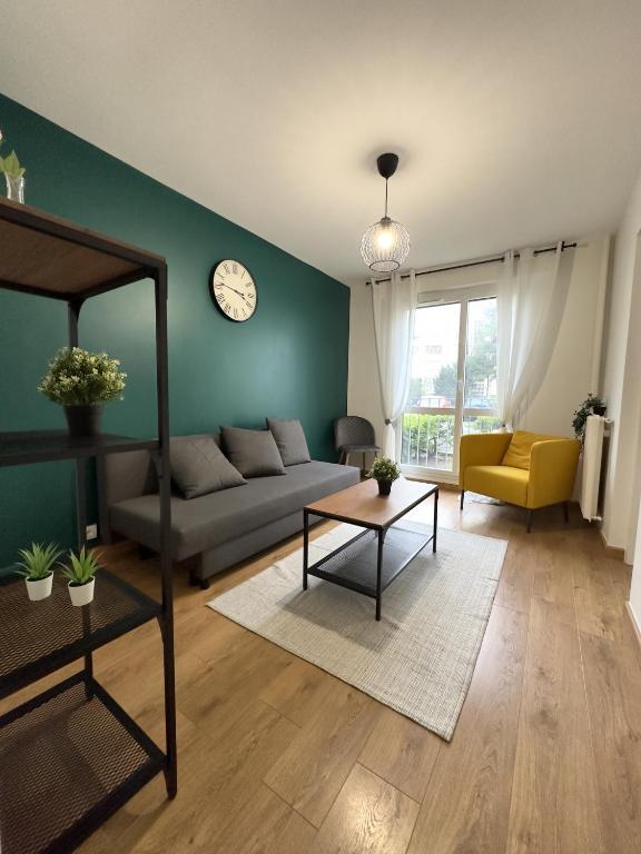 - un salon avec un canapé et un réveil sur le mur dans l'établissement La Loire Paisible - 10mn Centre ville, à Orléans