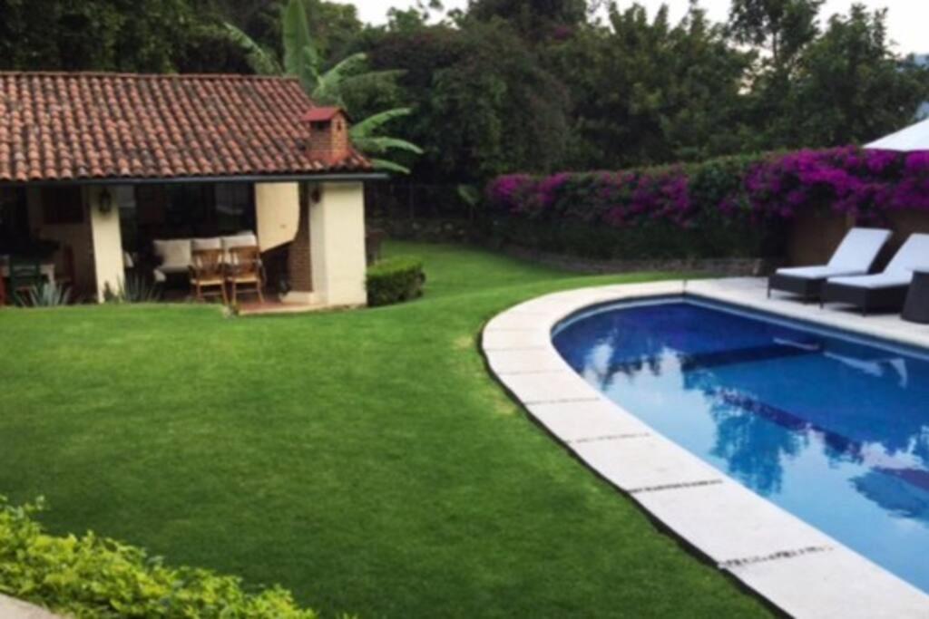 a backyard with a swimming pool and green grass at Hermosa Casa Tipica en Malinalco in Malinalco