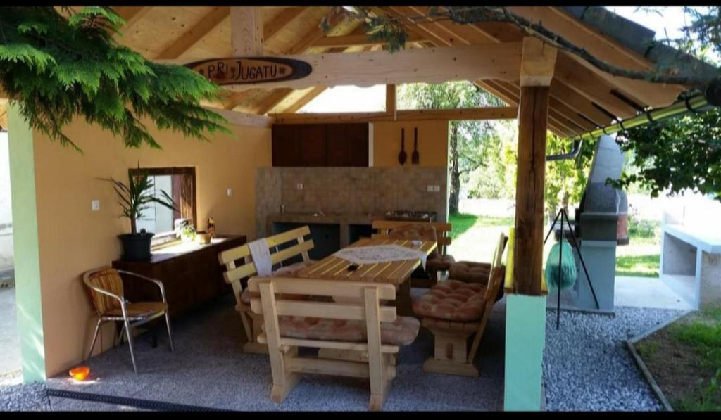 Vinica的住宿－SUN RIVER KOLPA Ap2，凉棚下的一张木桌和椅子