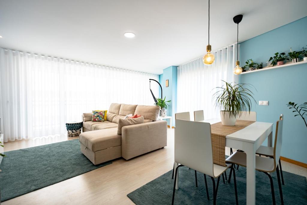 a living room with a table and a couch and a dining room at Oasis beach apartment in Figueira da Foz