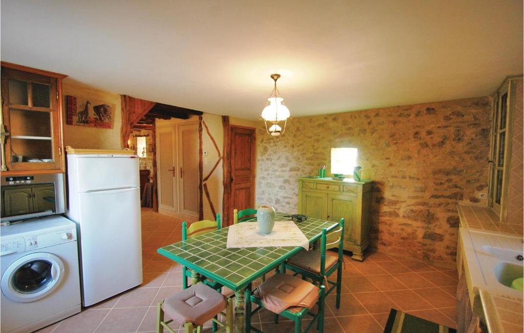 a small kitchen with a table and a refrigerator at Stunning Home In Terrasspn-lavilledieu With 3 Bedrooms, Wifi And Outdoor Swimming Pool in Bouillac