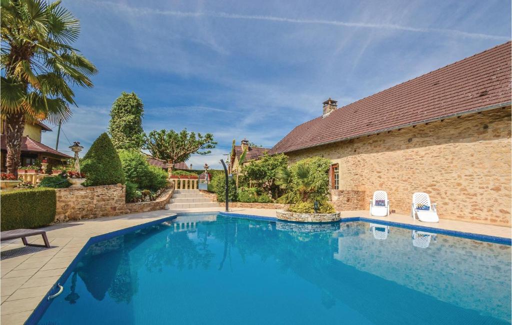 a swimming pool with two chairs next to a building at Stunning Home In Terrasspn-lavilledieu With 3 Bedrooms, Wifi And Outdoor Swimming Pool in Bouillac