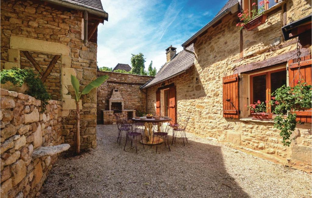 a patio with a table and chairs in a stone building at Stunning Home In Terrasspn-lavilledieu With 3 Bedrooms, Wifi And Outdoor Swimming Pool in Bouillac