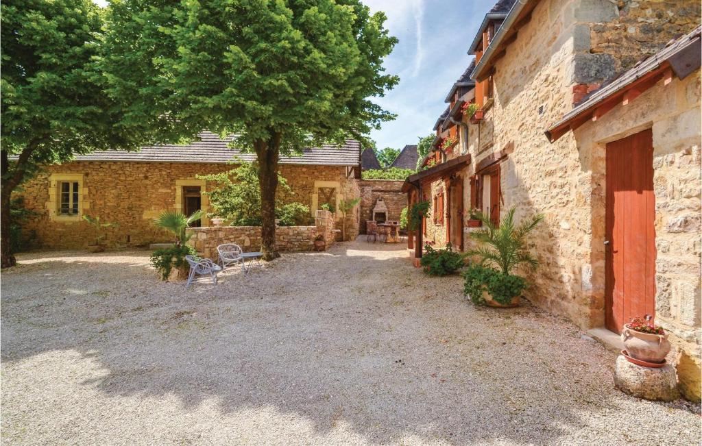 a courtyard of an old stone building with a tree at Stunning Home In Terrasspn-lavilledieu With 3 Bedrooms, Wifi And Outdoor Swimming Pool in Bouillac
