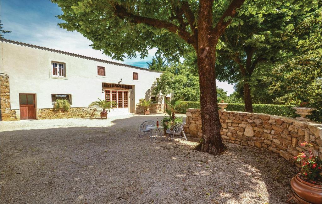 a building with a tree and a stone wall at Stunning Home In Terrasspn-lavilledieu With 3 Bedrooms, Wifi And Outdoor Swimming Pool in Bouillac