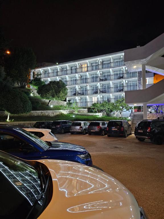 un estacionamiento con autos estacionados frente a un edificio en Hotel Villa Garden Ulcinj-Ulqin en Ulcinj