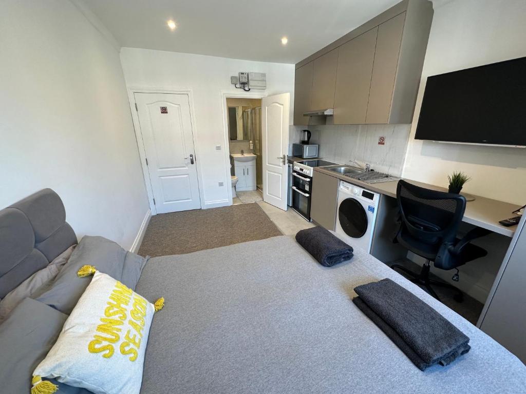een woonkamer met een bank en een keuken bij Bright Modern, 1 Bed Flat, 15 Mins Away From Central London in Hendon