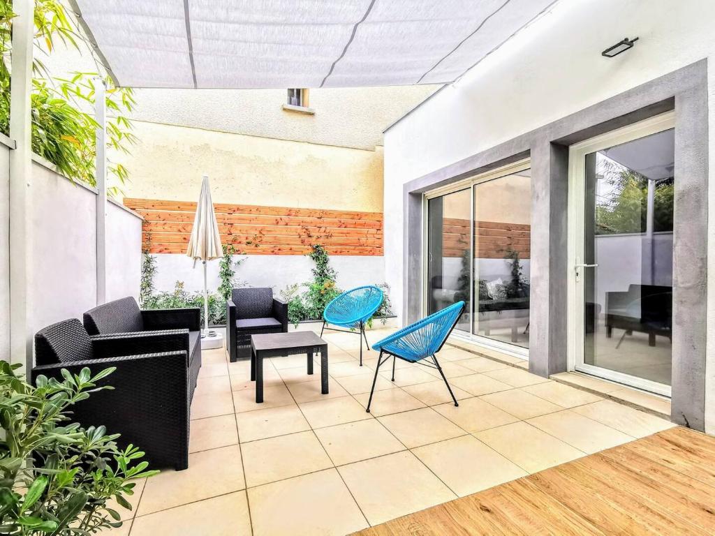 una sala de estar abierta con muebles y ventanas en Jolie Villa avec jacuzzi Hôpitaux facultés, en Montpellier