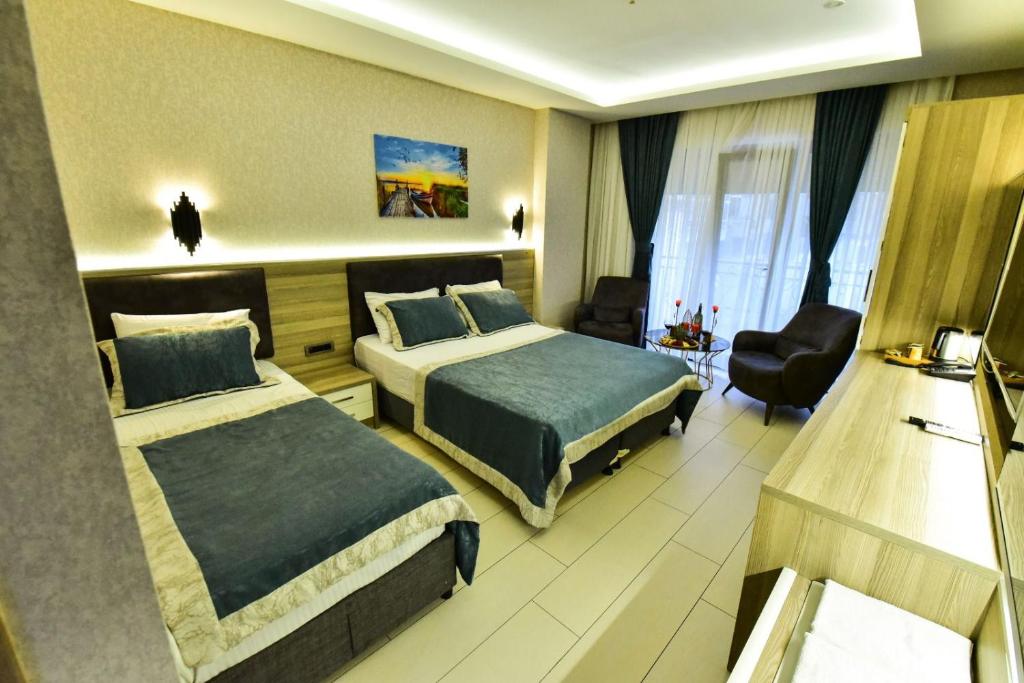 una habitación de hotel con 2 camas y una silla en RESTWON SUIT en Estambul