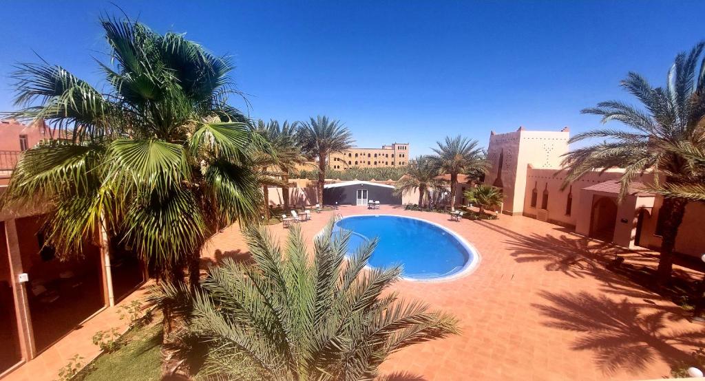 - une vue sur la piscine bordée de palmiers dans l'établissement Kasbat Aferdou, à Errachidia