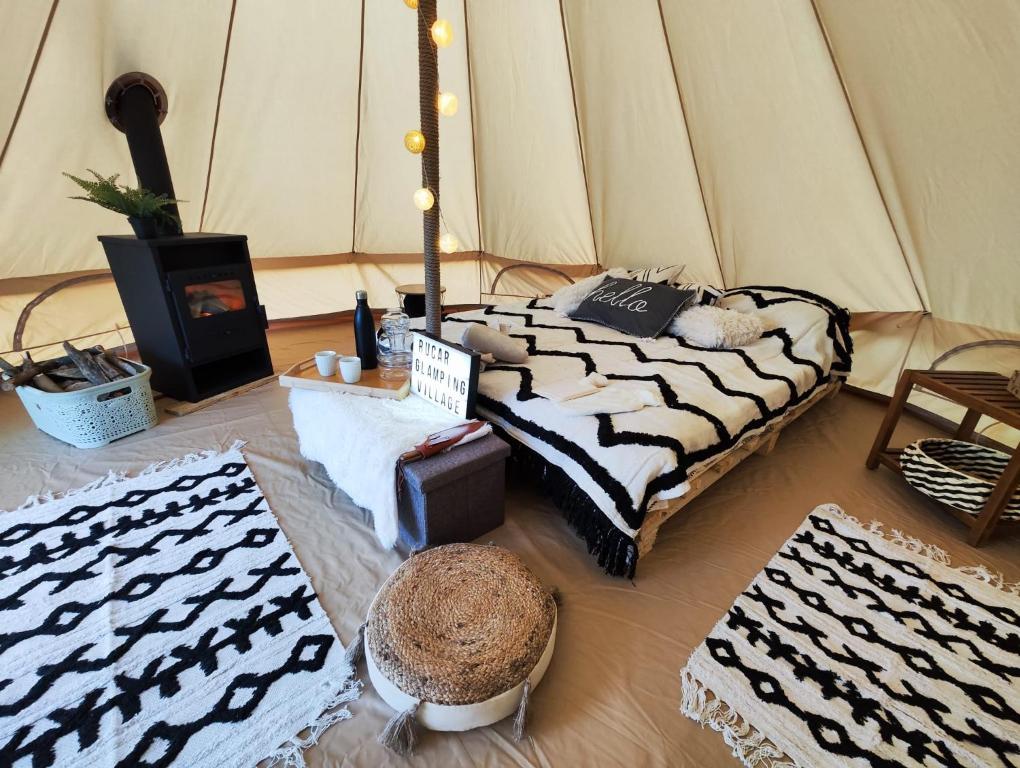 een kamer met een bed en wat tapijten in een tent bij Rucăr Glamping Village in Rucăr