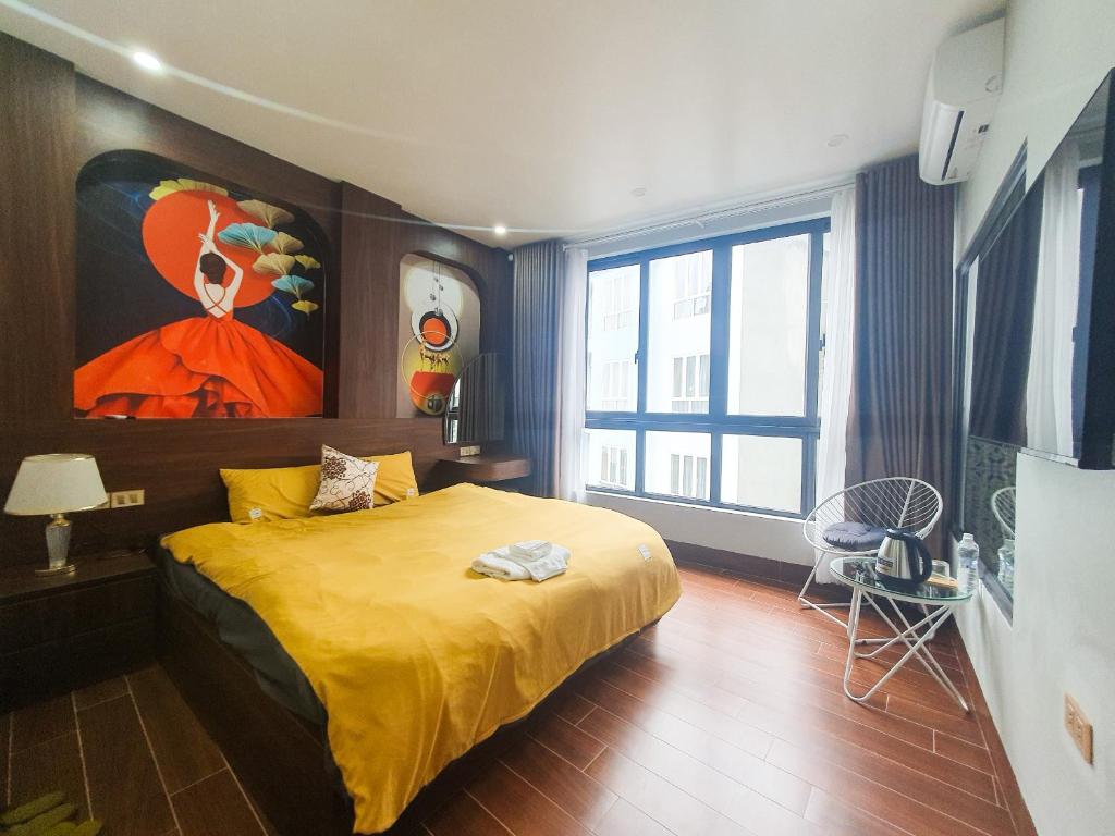 Un dormitorio con una cama amarilla con una pintura en la pared en Tuan Lien Villa Tam Dao, en Tam Ðảo