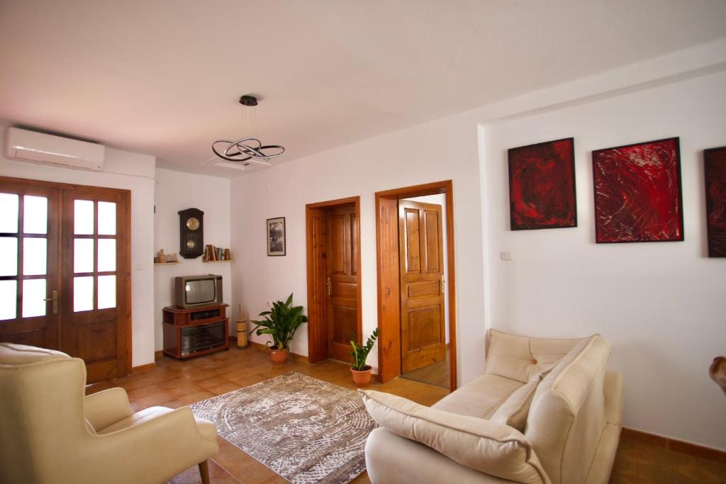 地拉那的住宿－E&E Home Sweet Home，客厅配有两把椅子和电视