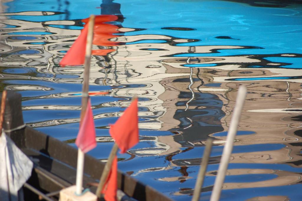 une rangée de drapeaux rouges dans l'eau dans l'établissement Ferienhaus in der Hansestadt mit Blick auf Ostsee, à Wismar