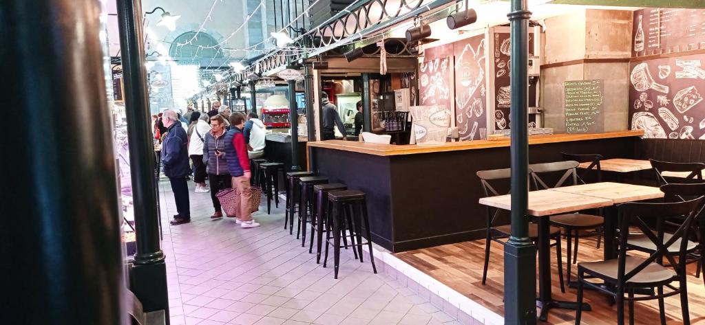 Un restaurante con mesas y sillas y gente caminando por la calle. en La Douce Cathare, en Carcassonne