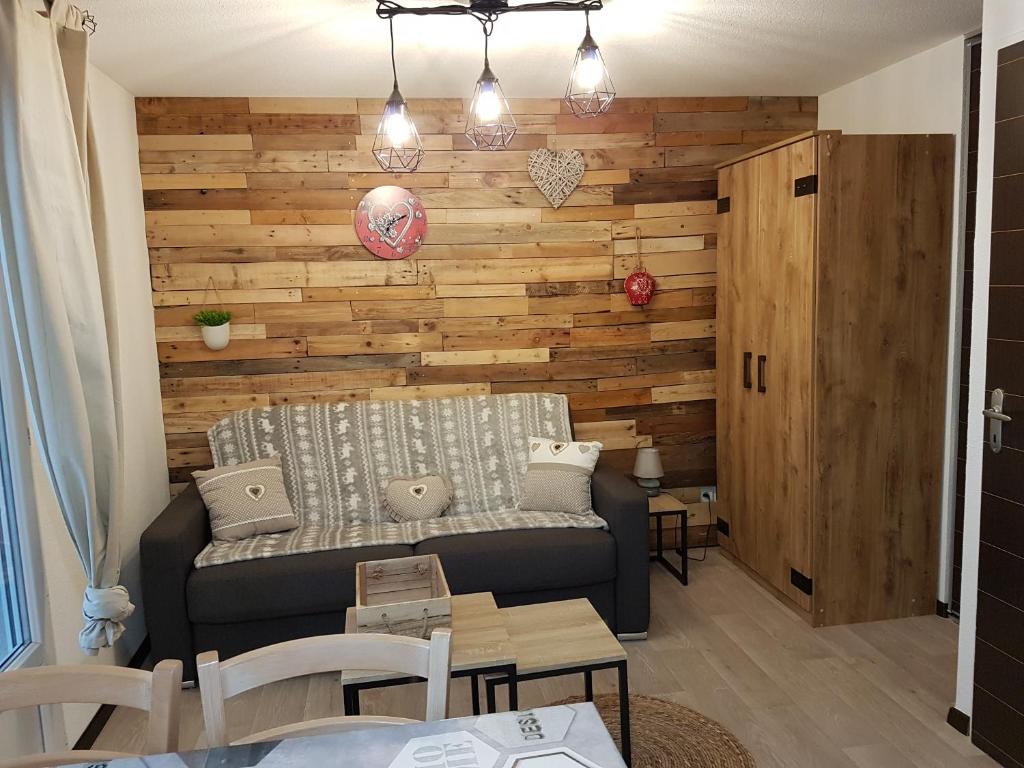 - un salon avec un canapé et un mur en bois dans l'établissement Bel Apt 4 pers dernier étage balcon vue montagne, à Luz-Saint-Sauveur