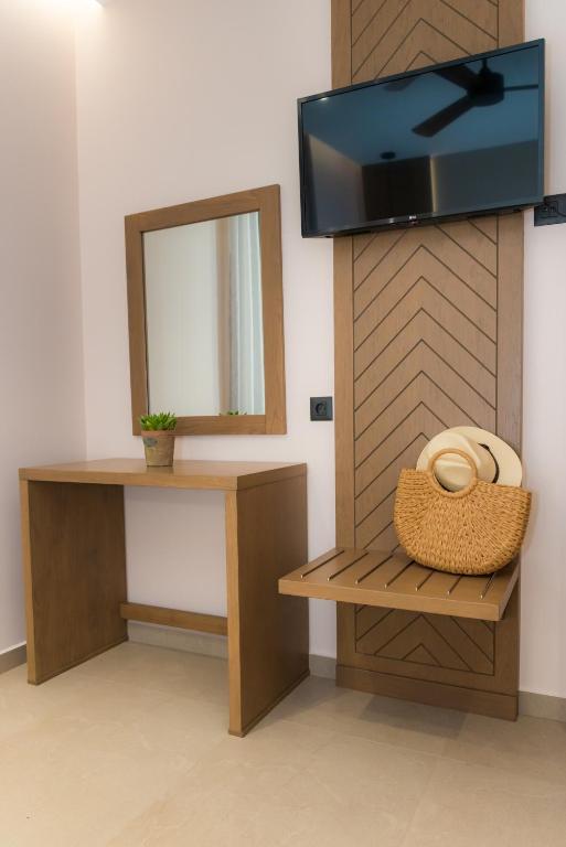a room with a mirror and a tv on a wall at Nissos Apartments in Myrina